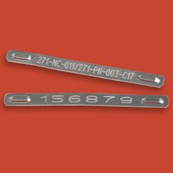 Two Stainless Steel Cable Marking Tags with end slots rest on a red background. One tag is engraved with "271-MC-011/271-PN-003-C17" and the other displays "156879".